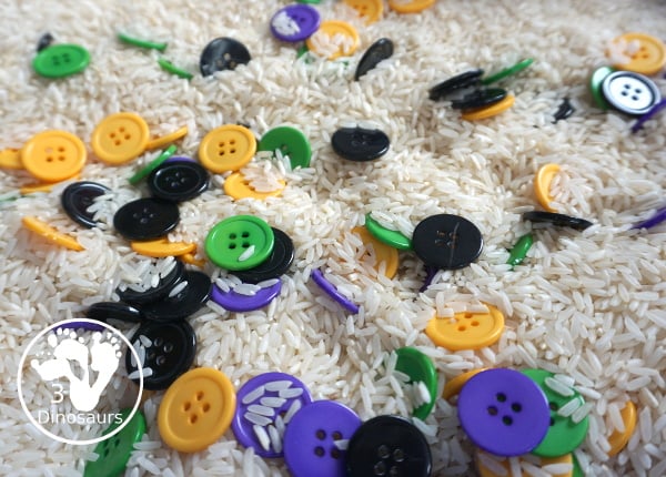 Halloween Button Black, Orange, Green & Purple Sensory Bin - is a simple button sensory bin with Halloween colors for black, orange, purple and green. They are in a rice filled for the base - 3Dinosaurs.com