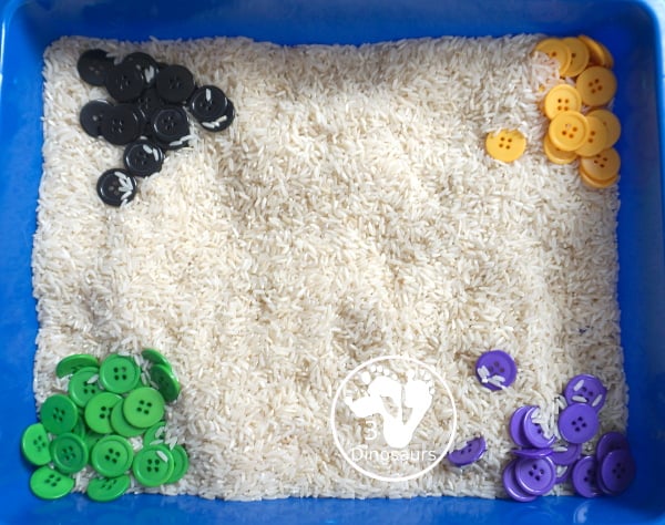 Halloween Button Black, Orange, Green & Purple Sensory Bin - is a simple button sensory bin with Halloween colors for black, orange, purple and green. They are in a rice filled for the base - 3Dinosaurs.com