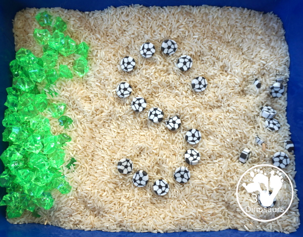 Soccer Sensory Bin - a simple sensory bin with rice filler with green rocks and soccer erasers for the parts of the sensory bin. A fun summer sport theme for kids. 3Dinosaurs.com