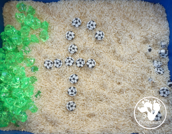 Soccer Sensory Bin - a simple sensory bin with rice filler with green rocks and soccer erasers for the parts of the sensory bin. A fun summer sport theme for kids. 3Dinosaurs.com