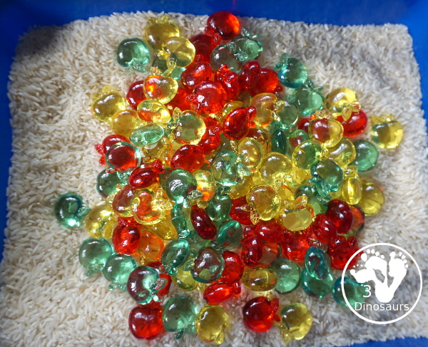 Simple Apple Sensory Bin - with acrylic apples and rice sensory bin. You have red apples, yellow apples, and green apples. This is a great sensory bin for the fall, and back to school. You can use it for any apple theme. 3Dinosaurs.com