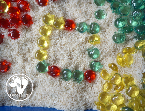 Simple Apple Sensory Bin - with acrylic apples and rice sensory bin. You have red apples, yellow apples, and green apples. This is a great sensory bin for the fall, and back to school. You can use it for any apple theme.  3Dinosaurs.com