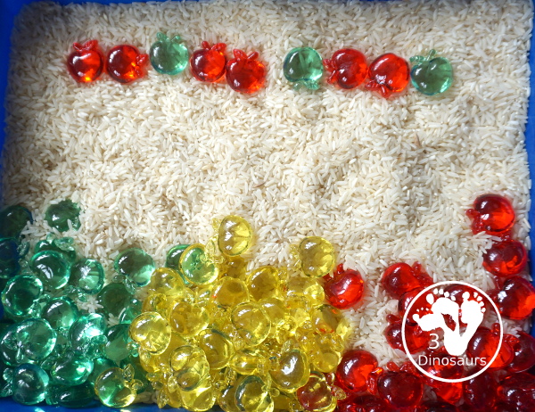 Simple Apple Sensory Bin - with acrylic apples and rice sensory bin. You have red apples, yellow apples, and green apples. This is a great sensory bin for the fall, and back to school. You can use it for any apple theme.  3Dinosaurs.com