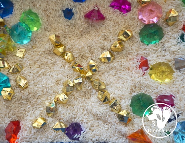 Pirate Treasure Rice Sensory Bin - a run sensory bin with gold rocks and colored gems with a rice filler for a Pirate theme that is great for Talk Like a Pirate Day or a summer pirate theme. - 3Dinosaurs.com